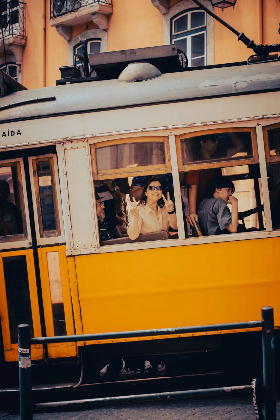 Passengers gazing out from a vintage yellow tram in Lisbon (Hetketabamus, liikumise ja vaatlemise kombinatsioon)