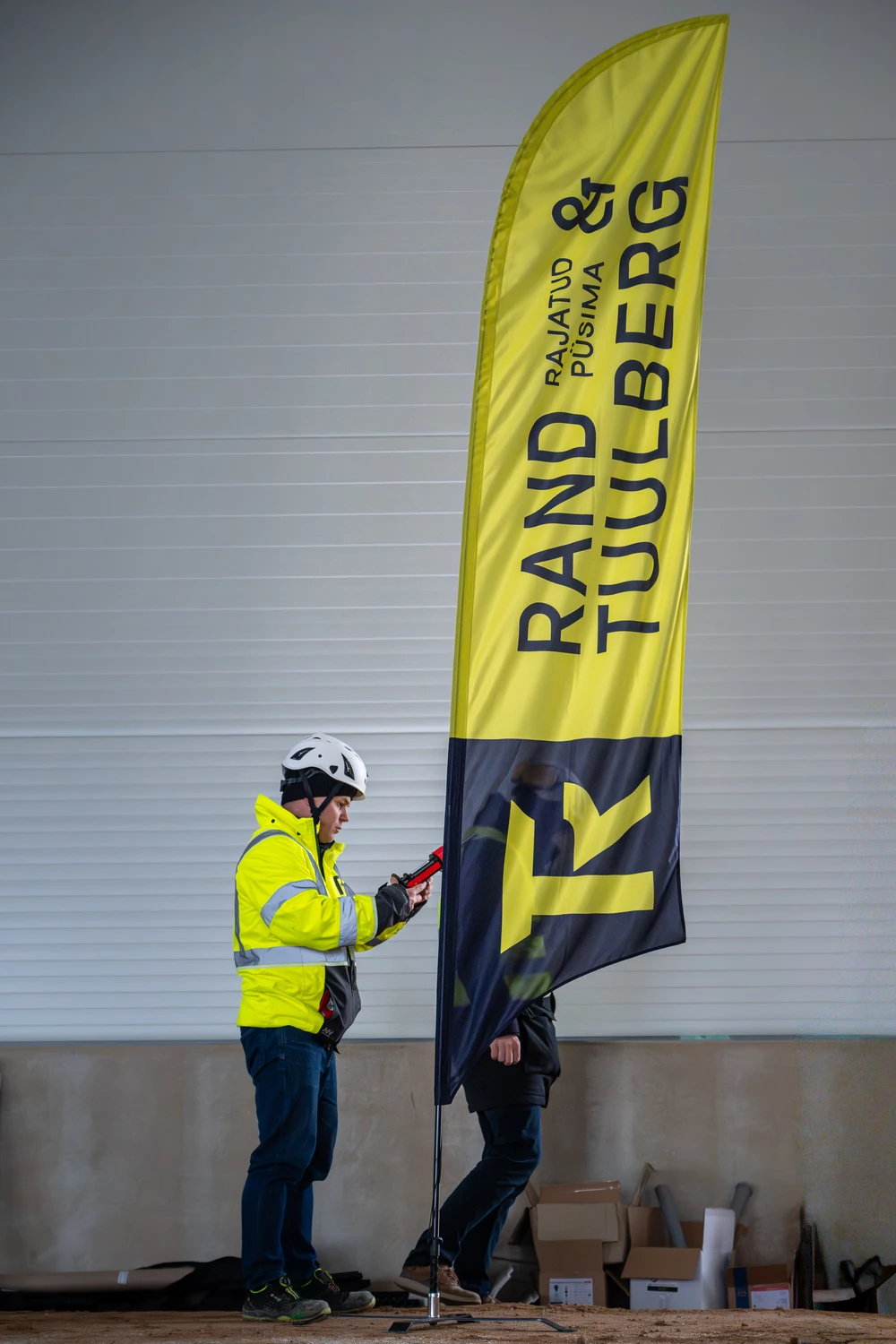 Ehitustööline Rand & Tuulberg logoga kiivriga