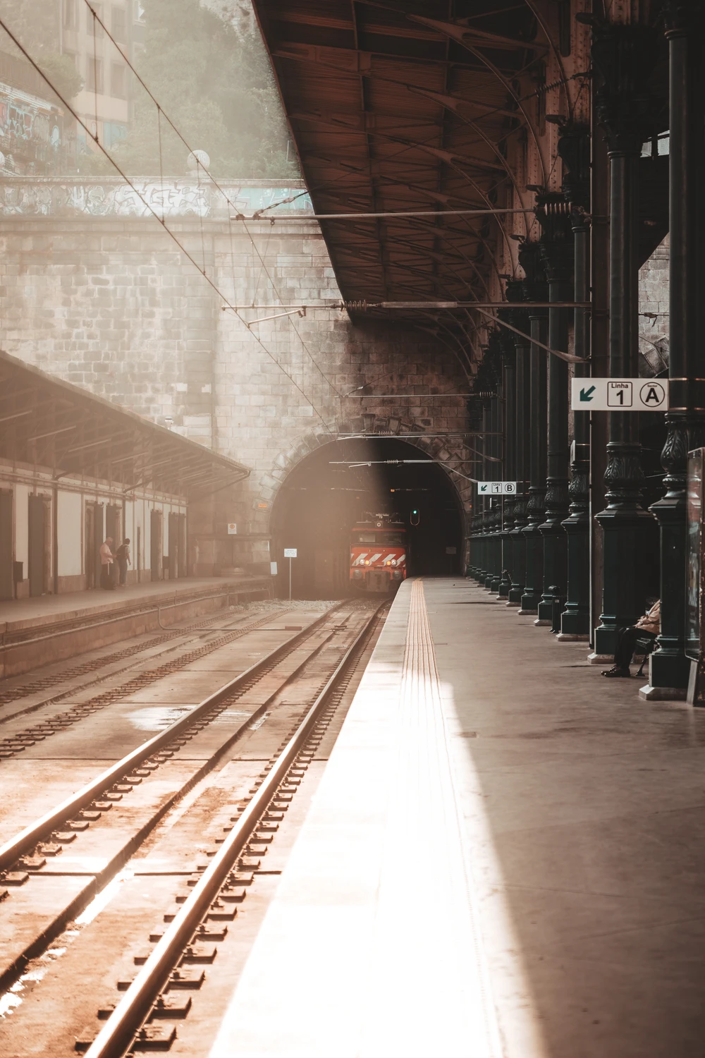 rain station platform with light beam and rails, cinematic urban mood